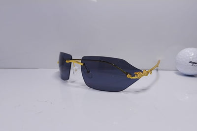 Sunglasses with gold frame and dark lenses on a white surface
