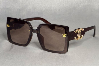 Chanel sunglasses with gold accents on a light gray background