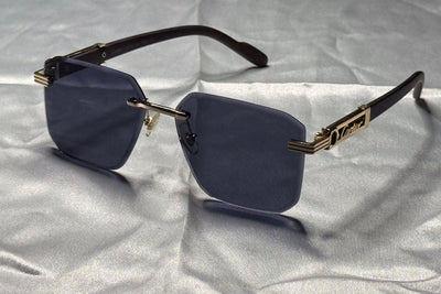 Sunglasses with gold accents on a textured gray surface