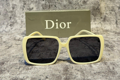 Sunglasses with 'Dior' logo on a textured surface