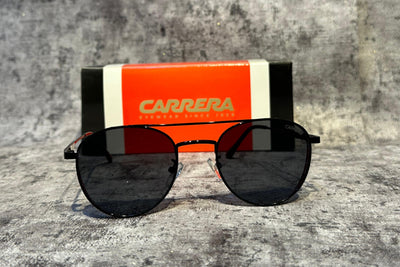 Sunglasses with Carrera case on a textured surface