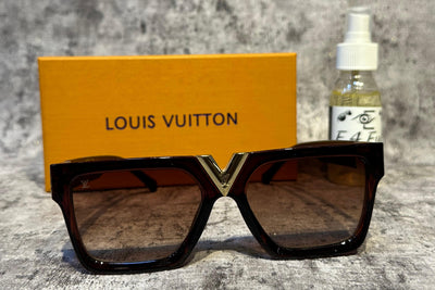 Louis Vuitton sunglasses with a yellow box and a bottle in the background on a textured surface