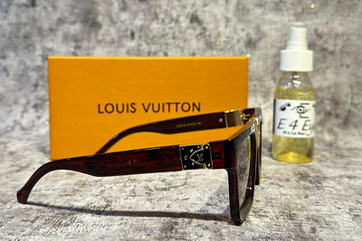 Louis Vuitton sunglasses with a bottle and box on a textured surface