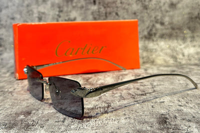 Cartier sunglasses on a textured surface with an orange box in the background