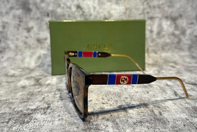 Sunglasses with colorful frame design on a textured surface with Gucci card