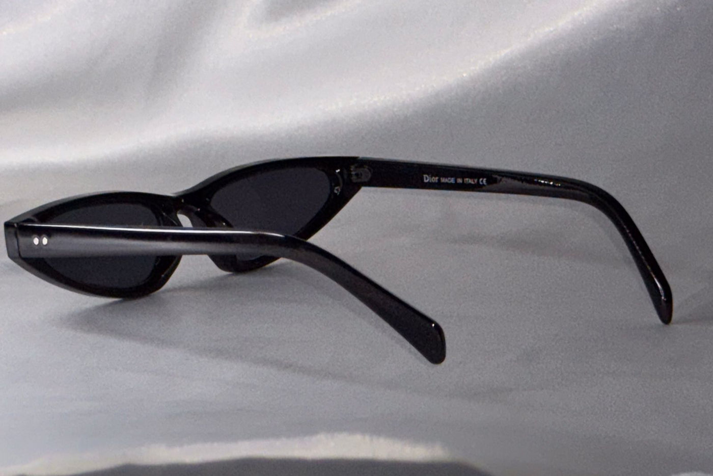 Black sunglasses on a light gray fabric background