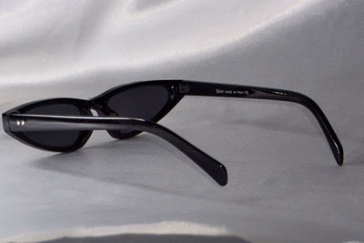 Black sunglasses on a light gray fabric background